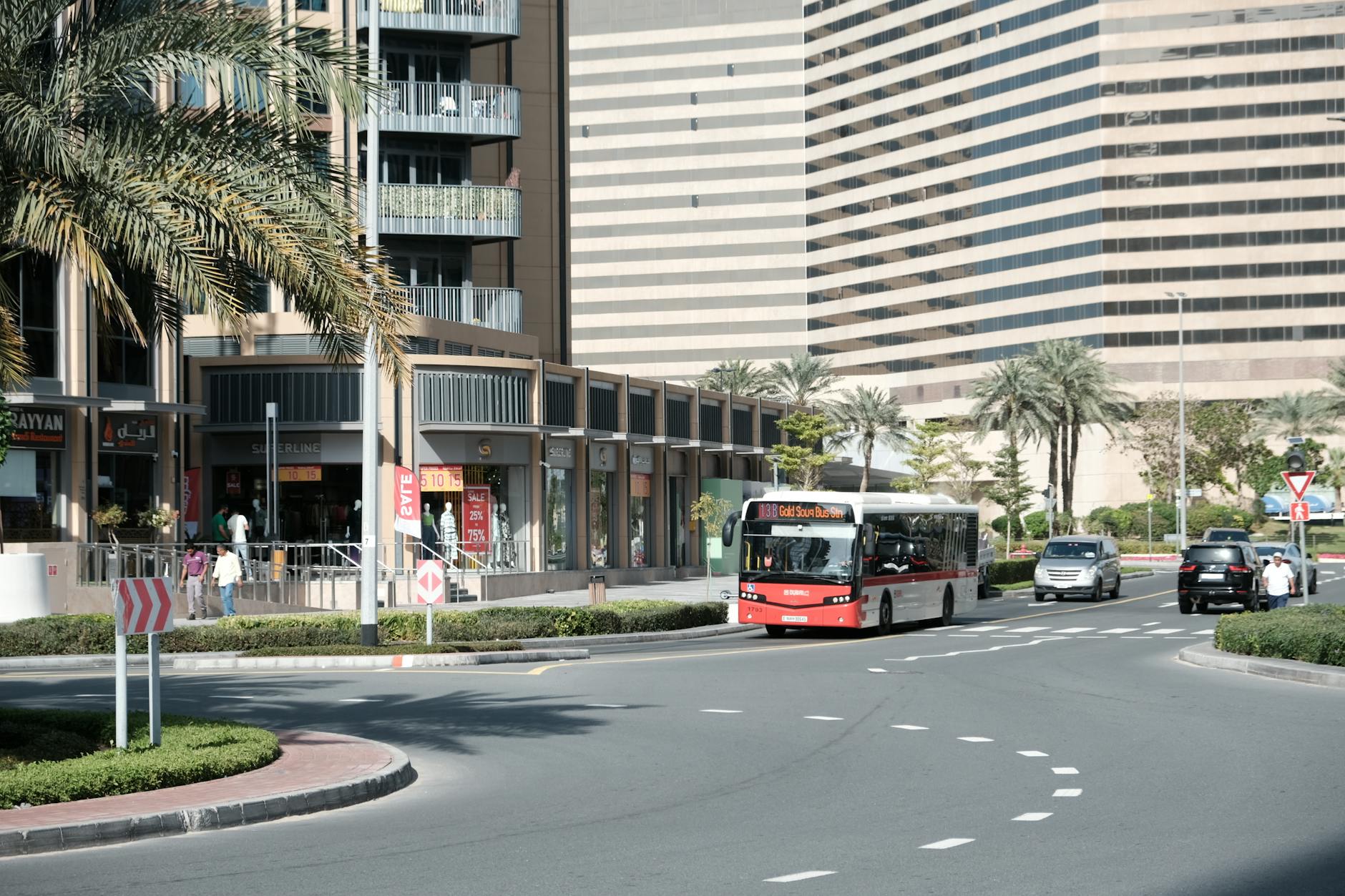 Dubai street with RTA bus, shops, and palm trees